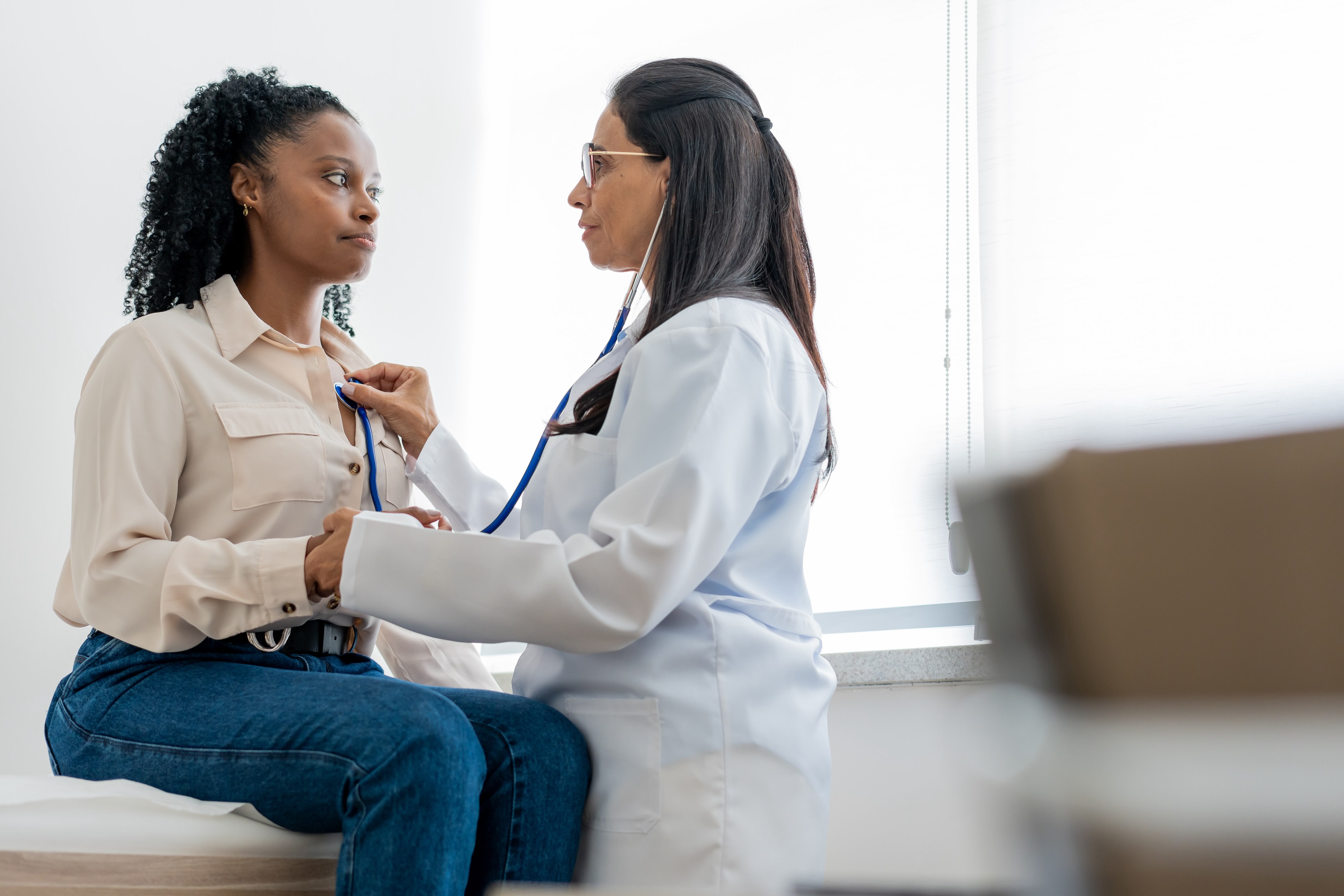 Doctor checking patients heart with stethoscope