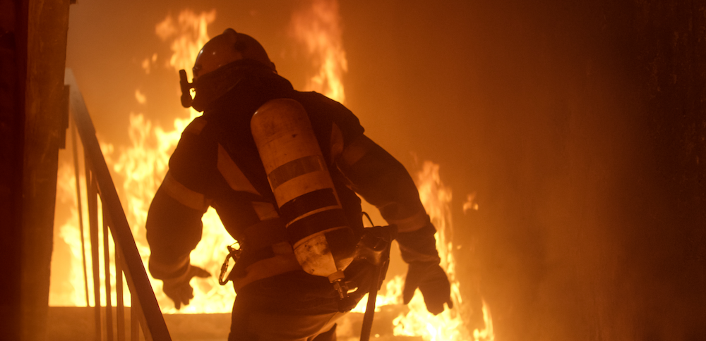 Firefighter going up burning stairs
