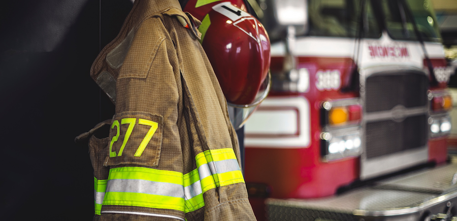 Firefighter uniform with firetruck in the background