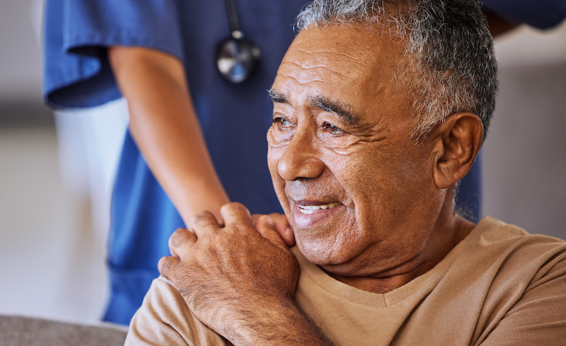 Cancer patient holding hand of nurse and smiling