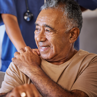Cancer patient holding hand of nurse and smiling
