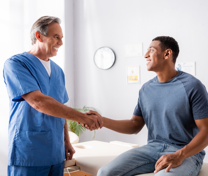 Doctor shaking hands with smiling patient