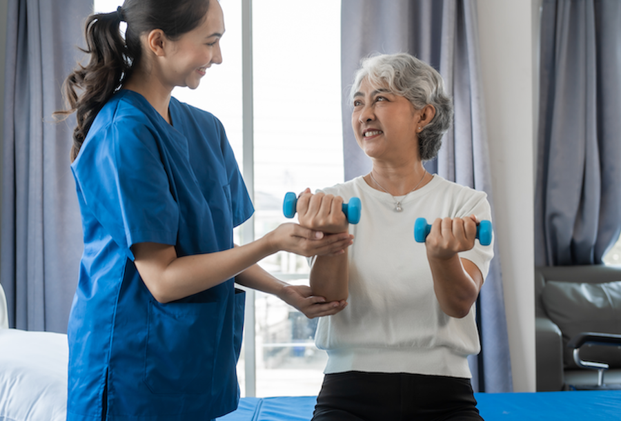Cancer provider working with patient on physical therapy hand and arm exercises