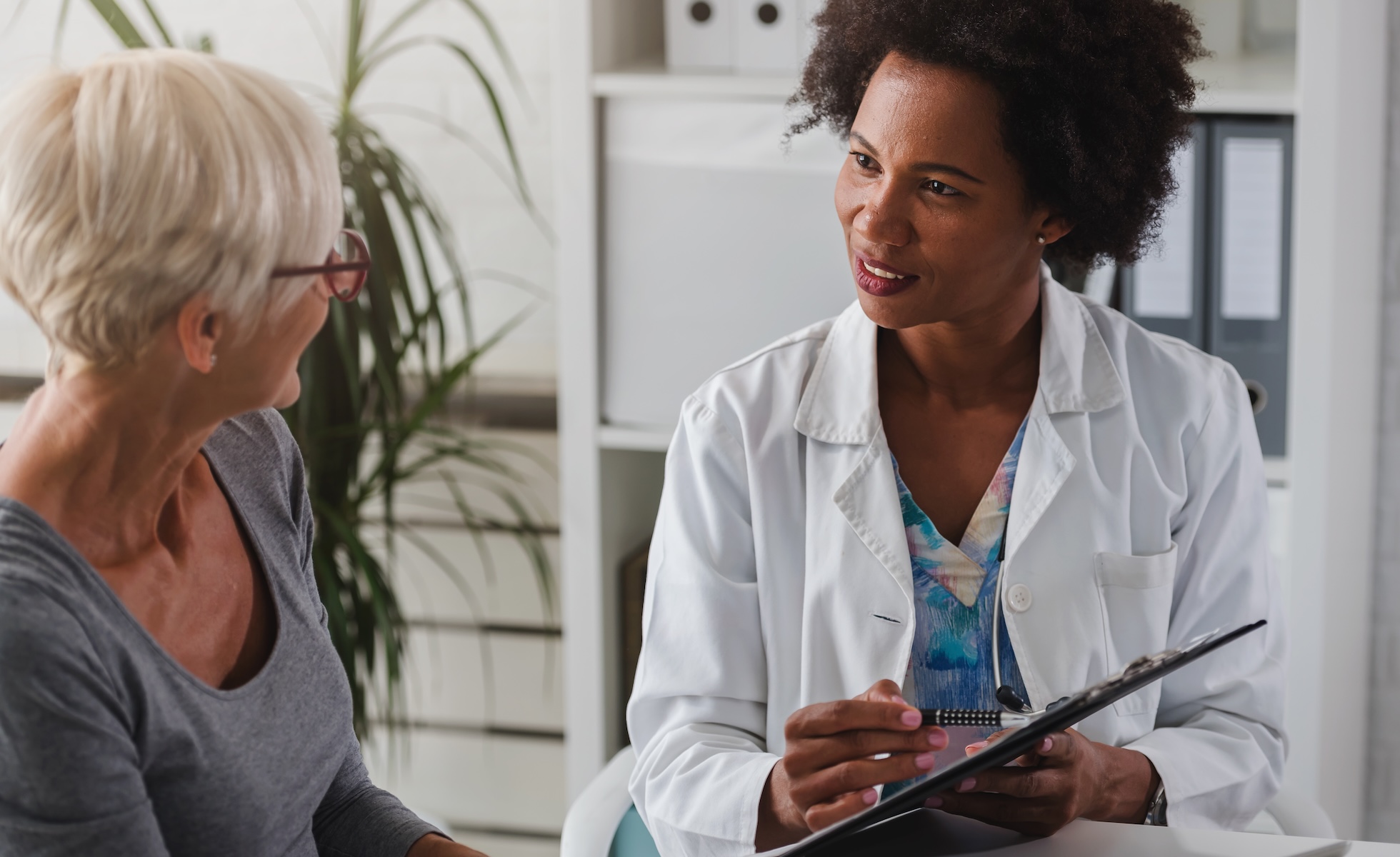 Doctor speaking to patient with clipboard about hepatic artery infusion