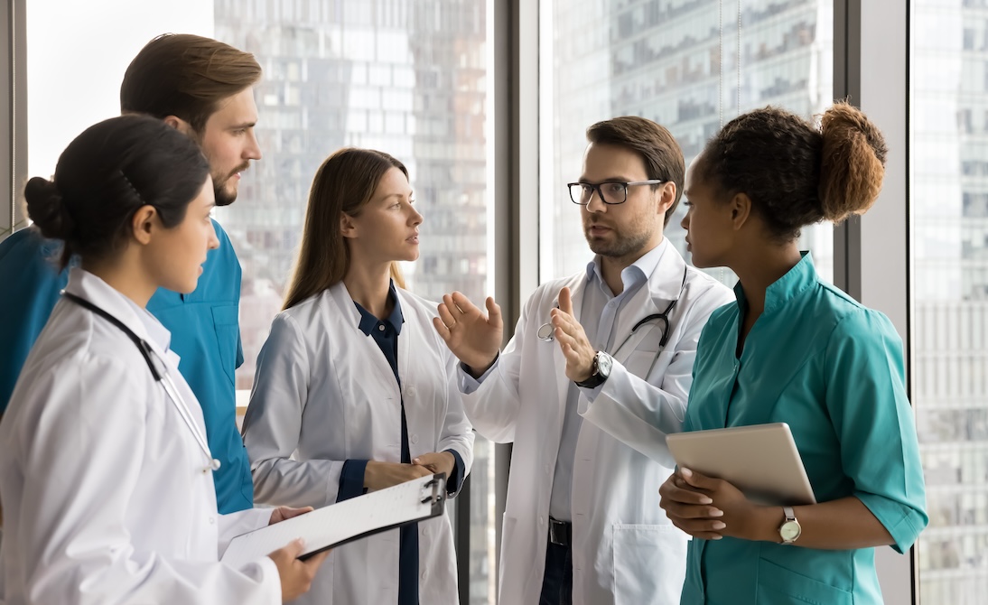Doctor speaking with team of supporting medical staff
